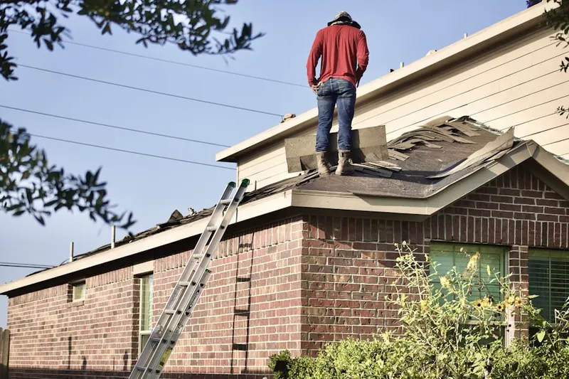Professional roofer working on a residential roof in Stanford
